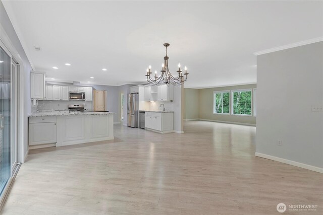 kitchen with an inviting chandelier, stainless steel appliances, open floor plan, baseboards, and recessed lighting