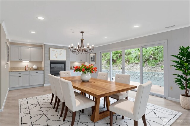dining room featuring crown molding, recessed lighting, light wood finished floors, and a notable chandelier