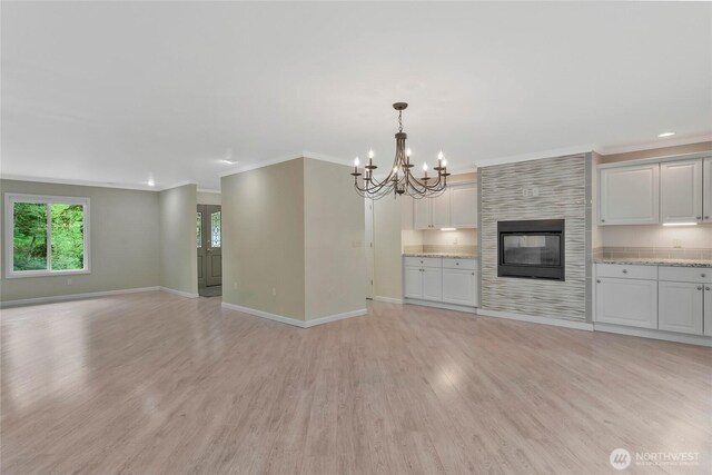 unfurnished living room featuring crown molding, a chandelier, light wood-style flooring, recessed lighting, and baseboards