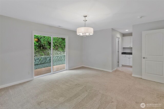 empty room featuring baseboards and light colored carpet