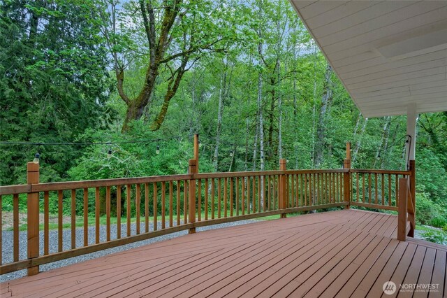 wooden terrace featuring a forest view