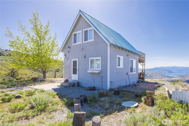 view of property exterior featuring a mountain view, a standing seam roof, and metal roof