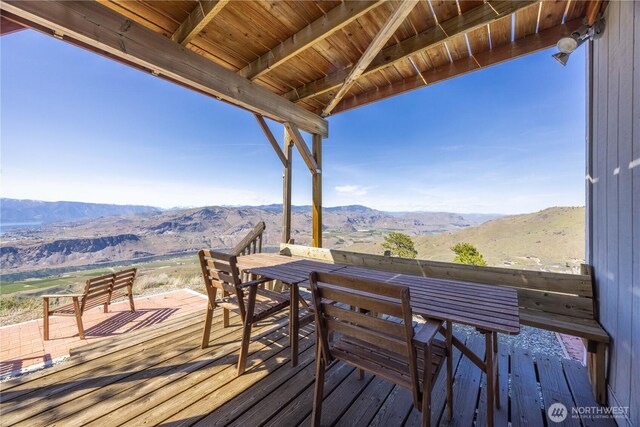 deck featuring outdoor dining area and a mountain view