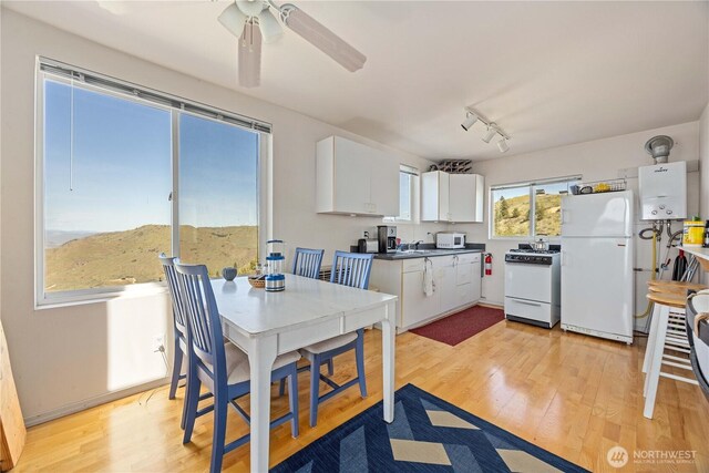 kitchen featuring a ceiling fan, white cabinetry, water heater, white appliances, and light wood-style flooring