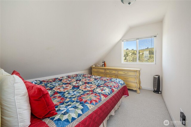 bedroom featuring baseboards, light colored carpet, and lofted ceiling