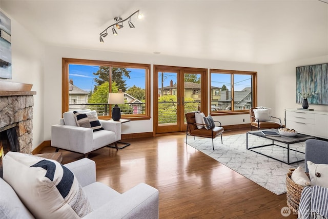 living area with healthy amount of natural light, wood finished floors, and a fireplace