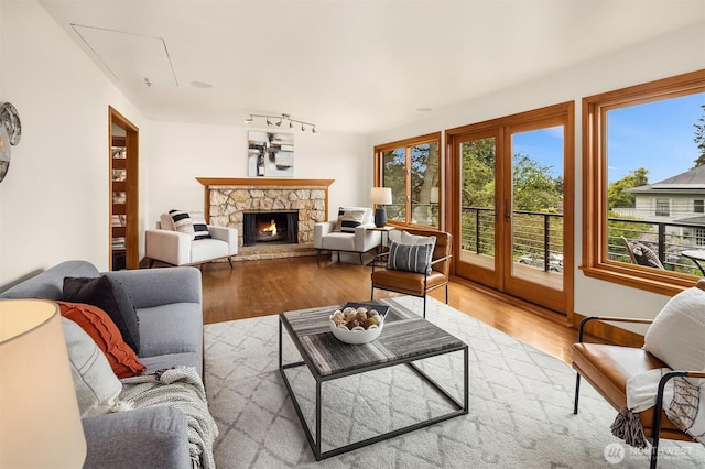 living room featuring attic access, wood finished floors, and a fireplace