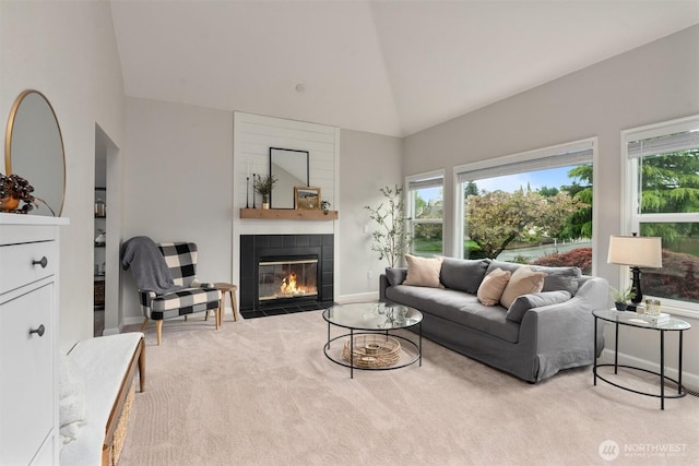 carpeted living room with baseboards, high vaulted ceiling, and a fireplace