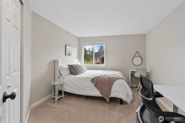 bedroom with baseboards and light colored carpet