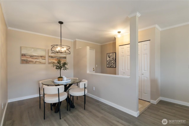 dining area with baseboards, crown molding, and wood finished floors