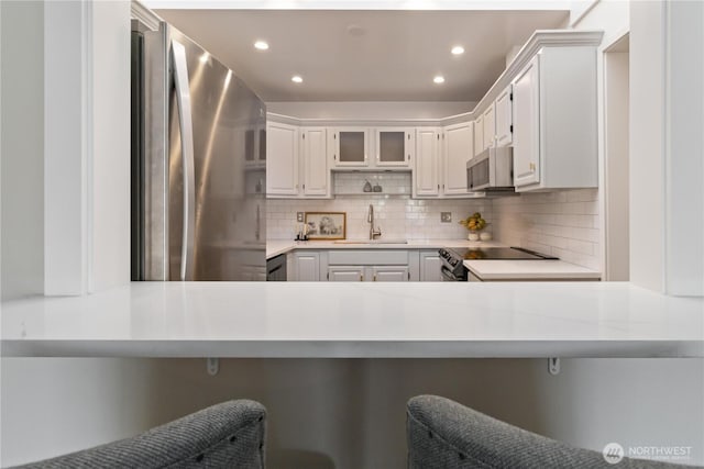 kitchen featuring recessed lighting, a sink, appliances with stainless steel finishes, and tasteful backsplash