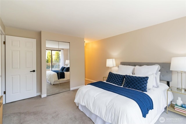 bedroom with baseboards, light carpet, and a closet
