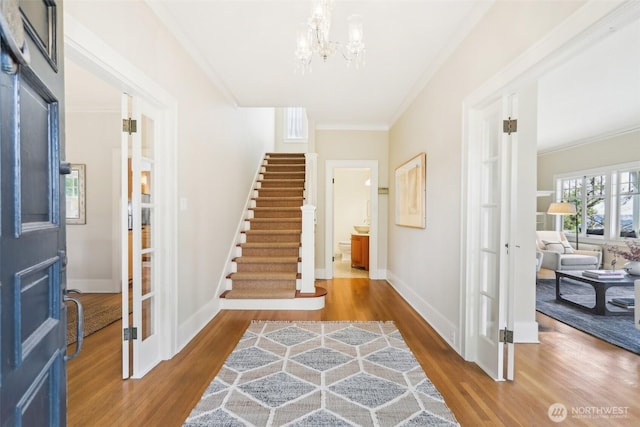 1238 E Newton St, Seattle, WA 98102 - foyer entrance featuring wood finished floors, ornamental molding, a chandelier, stairs, and baseboards