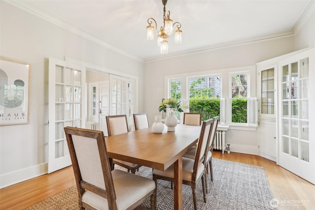1238 E Newton St, Seattle, WA 98102 - dining room with radiator, ornamental molding, french doors, light wood-type flooring, and a chandelier