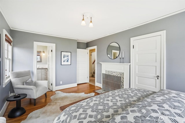 1238 E Newton St, Seattle, WA 98102 - bedroom featuring wood finished floors, crown molding, baseboards, a fireplace, and connected bathroom