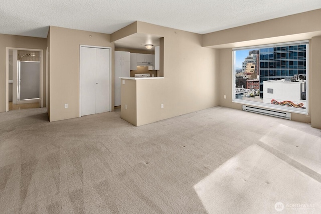 unfurnished living room with light colored carpet and a textured ceiling