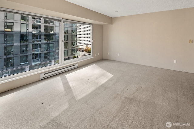 carpeted empty room featuring baseboard heating