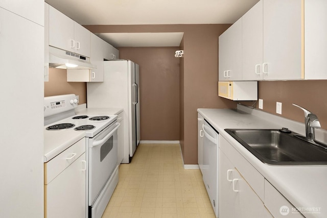 kitchen featuring a sink, light countertops, under cabinet range hood, and white appliances