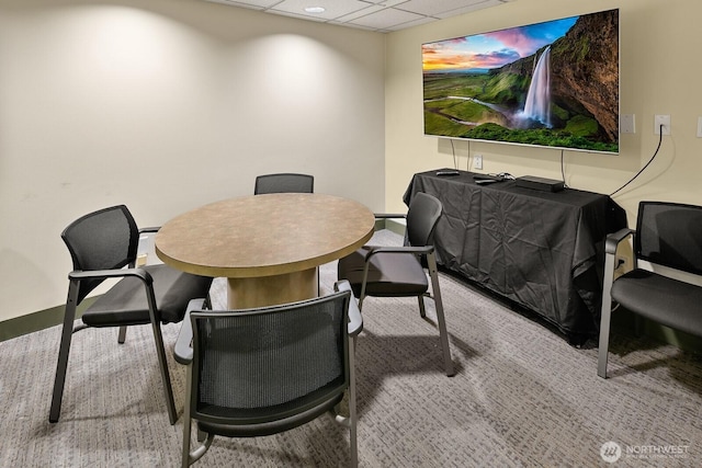 carpeted dining area with baseboards and a paneled ceiling