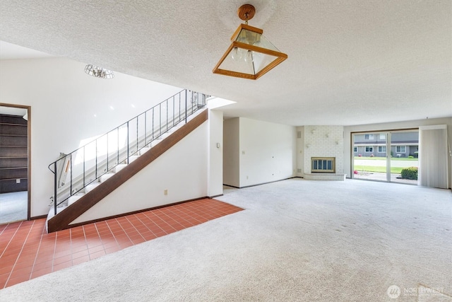 unfurnished living room featuring stairway, carpet floors, a fireplace, and a textured ceiling