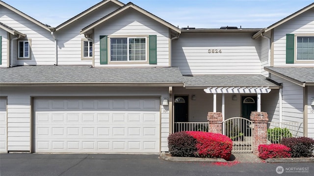 townhome / multi-family property featuring aphalt driveway, roof with shingles, and a garage