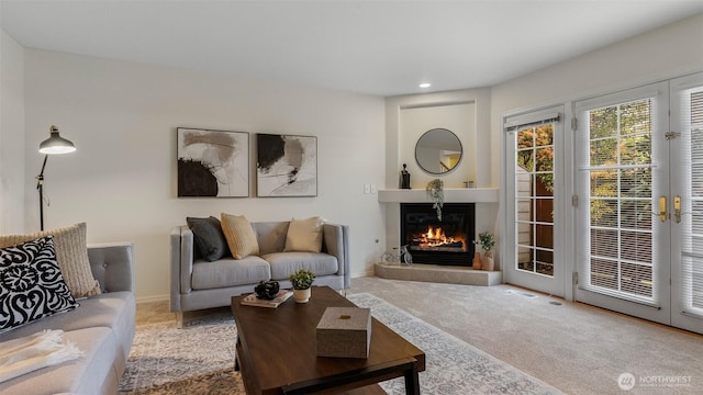 living area featuring a glass covered fireplace, carpet, recessed lighting, baseboards, and visible vents