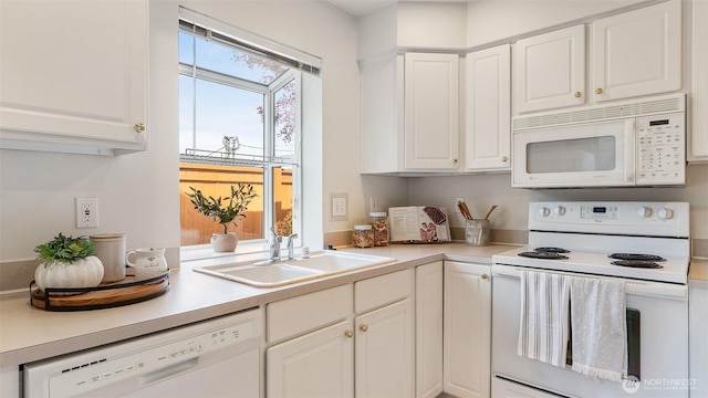 kitchen with a sink, white cabinetry, white appliances, and light countertops