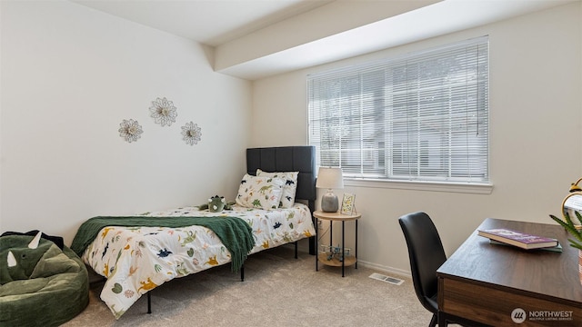 carpeted bedroom featuring baseboards and visible vents