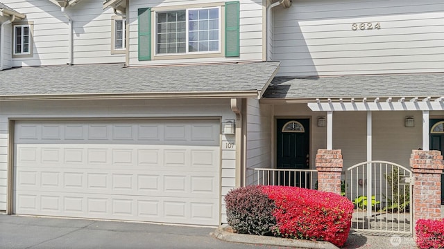 exterior space featuring a garage and a shingled roof