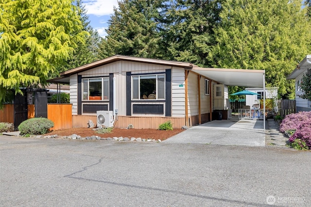 manufactured / mobile home featuring ac unit, fence, driveway, and an attached carport