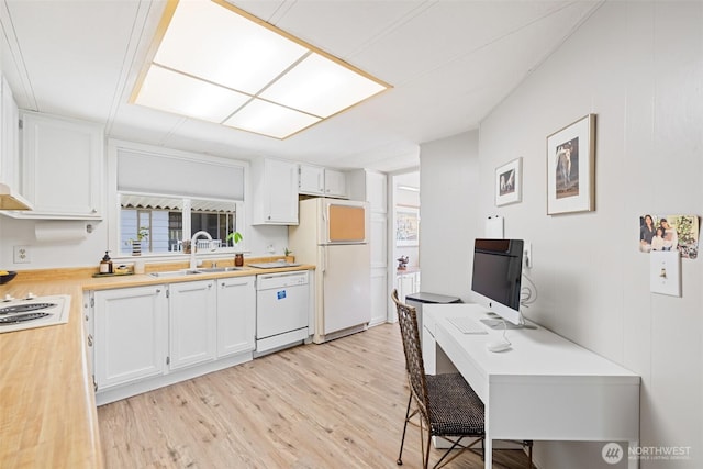 kitchen featuring light wood-style floors, a sink, white cabinetry, and white appliances