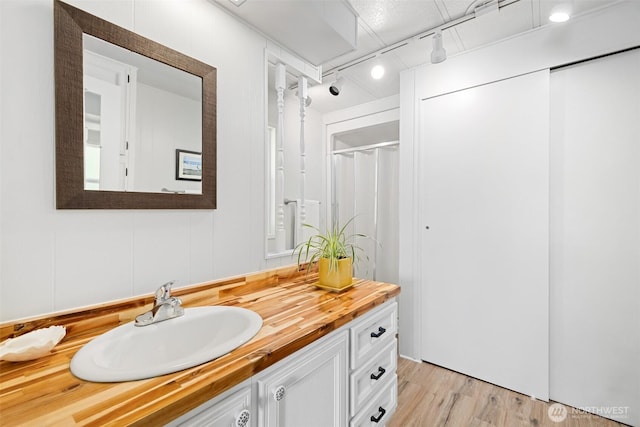 full bathroom with curtained shower, wood finished floors, and vanity
