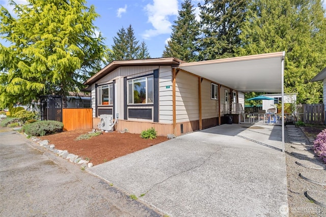 manufactured / mobile home featuring fence, ac unit, an attached carport, and driveway