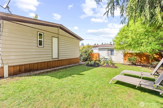 view of yard with fence and an outbuilding