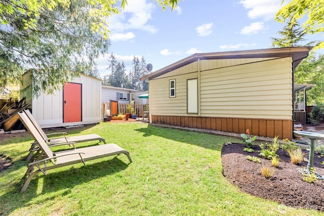view of yard featuring fence, an outbuilding, and a storage unit