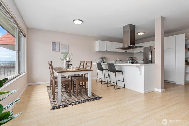 dining room featuring light wood-style floors and baseboards