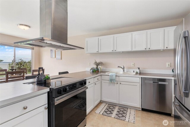 kitchen featuring light countertops, white cabinets, island exhaust hood, a sink, and stainless steel appliances