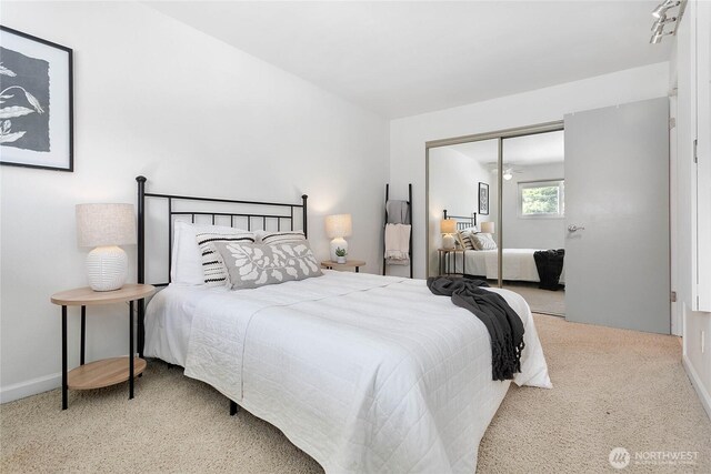 carpeted bedroom with a closet and baseboards