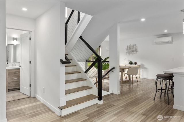 staircase with baseboards, a wall mounted air conditioner, wood finished floors, and recessed lighting