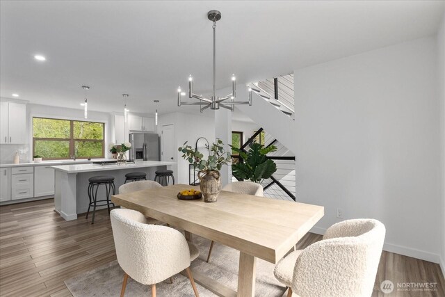 dining space featuring recessed lighting, baseboards, a chandelier, and light wood-type flooring
