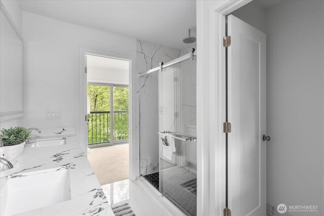 bathroom with a sink, a marble finish shower, and marble finish floor