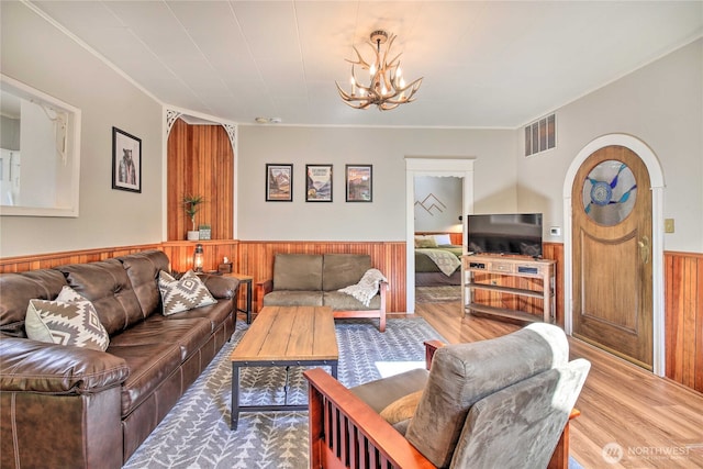 33823 State Route 706 Unit 1, Ashford, WA 98304 - living room with visible vents, wood finished floors, a wainscoted wall, wooden walls, and an inviting chandelier