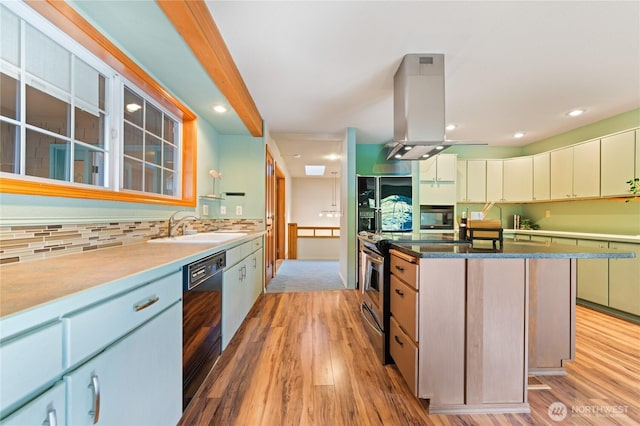 313 Willapa Pl, La Conner, WA 98257 - kitchen featuring island range hood, tasteful backsplash, a sink, black appliances, and light wood-style floors