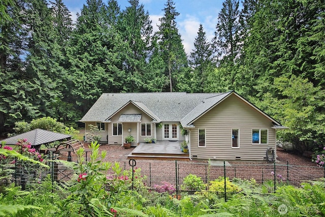 1180 Cedar Cir, Langley, WA 98260 - back of property with a vegetable garden, a wooden deck, and a shingled roof