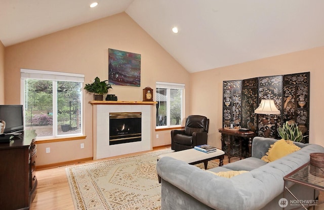 1180 Cedar Cir, Langley, WA 98260 - living room with light wood finished floors, healthy amount of natural light, a tile fireplace, high vaulted ceiling, and recessed lighting