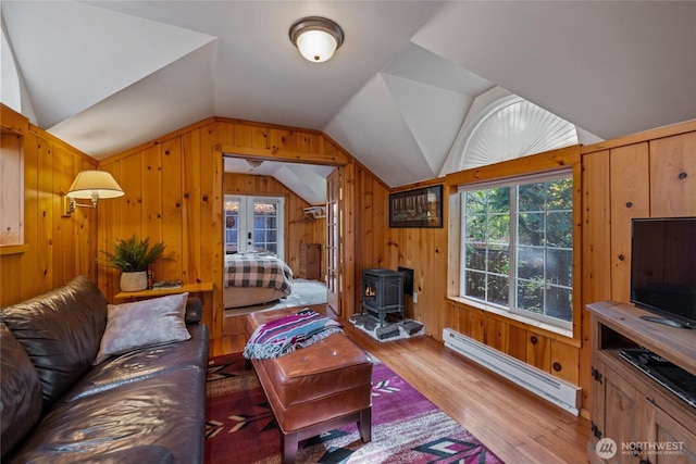33823 State Route 706 E Unit 2, Ashford, WA 98304 - living area featuring wooden walls, baseboard heating, a wood stove, wood finished floors, and lofted ceiling