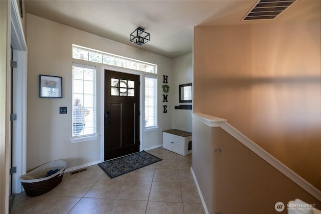 entryway with light tile patterned flooring, baseboards, and visible vents