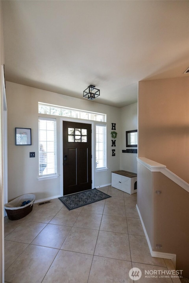 entrance foyer featuring plenty of natural light, baseboards, and light tile patterned floors