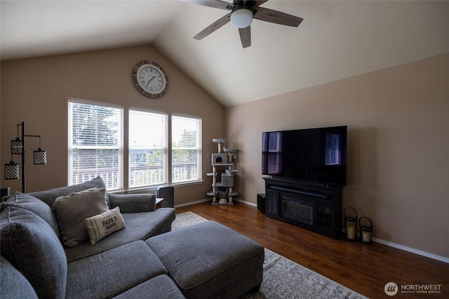 living area featuring baseboards, ceiling fan, vaulted ceiling, and wood finished floors