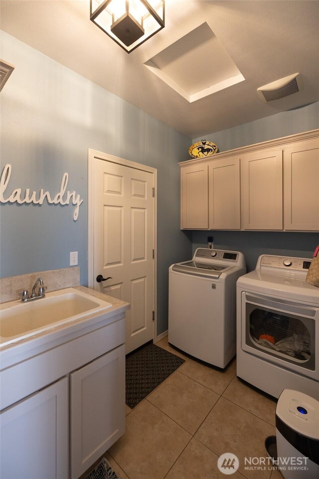 washroom with visible vents, a sink, cabinet space, independent washer and dryer, and light tile patterned floors